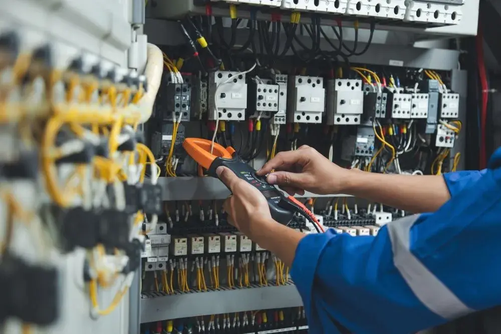 Electrician testing a control panel