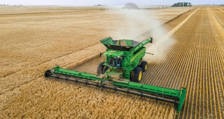 John Deere combine harvesting wheat